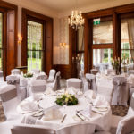The William Morris Suite at Mercure Burton Upon Trent Newton Park Hotel, set up for a wedding breakfast, windows looking out onto grounds